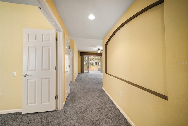 hall featuring baseboards and carpet floors