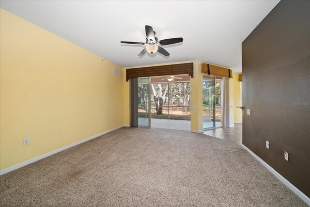 carpeted spare room featuring visible vents, baseboards, and ceiling fan