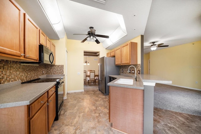 kitchen with a sink, black appliances, a peninsula, and a ceiling fan