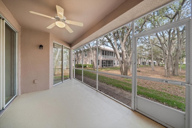 unfurnished sunroom with ceiling fan