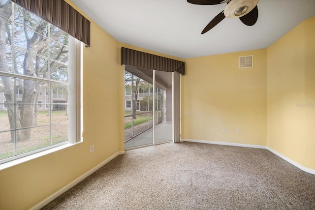 empty room with visible vents, baseboards, carpet, and ceiling fan