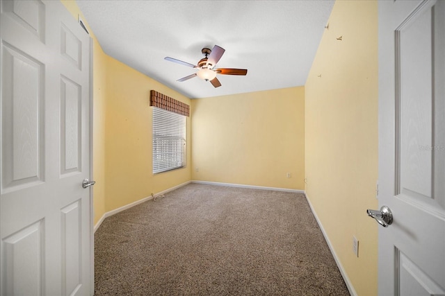 spare room featuring carpet, baseboards, and ceiling fan