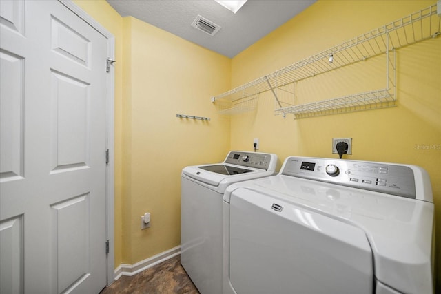 laundry area featuring visible vents, baseboards, washing machine and dryer, and laundry area