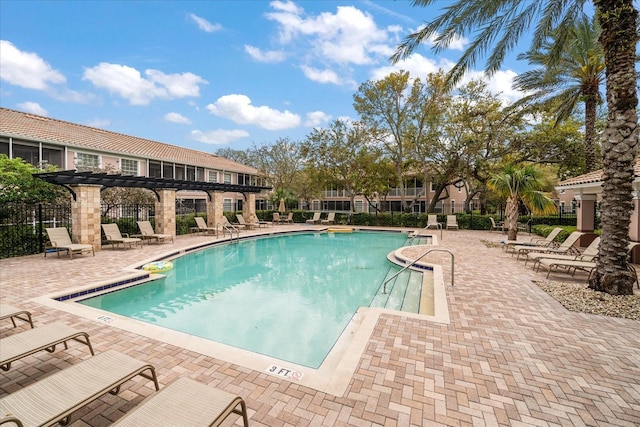 pool with a patio area, fence, and a pergola