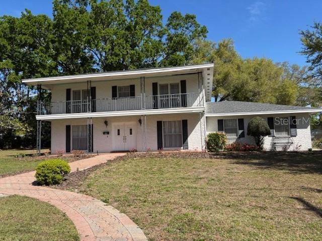 front of property with a balcony and a front yard