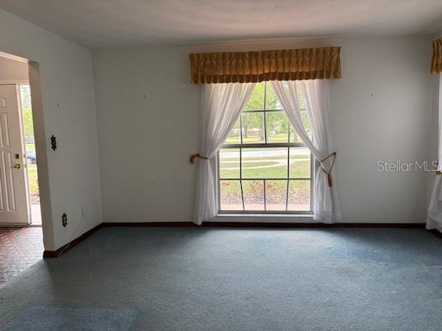 empty room featuring baseboards and carpet floors