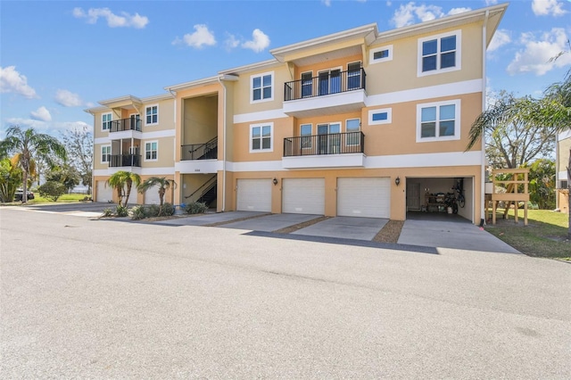 exterior space featuring stucco siding, concrete driveway, and an attached garage