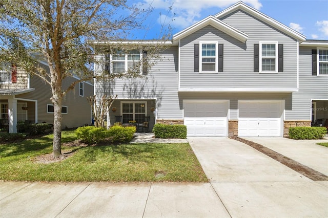 townhome / multi-family property featuring stone siding, a garage, driveway, and a front lawn