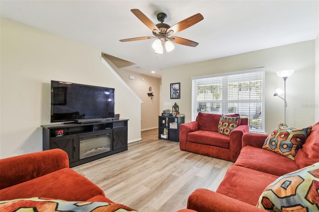 living room featuring a ceiling fan, wood finished floors, and baseboards