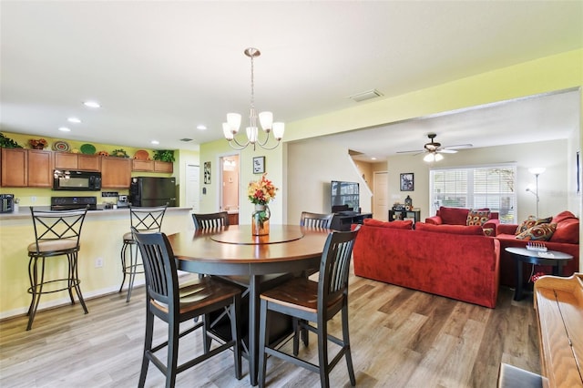 dining space with recessed lighting, visible vents, light wood-style flooring, and ceiling fan with notable chandelier