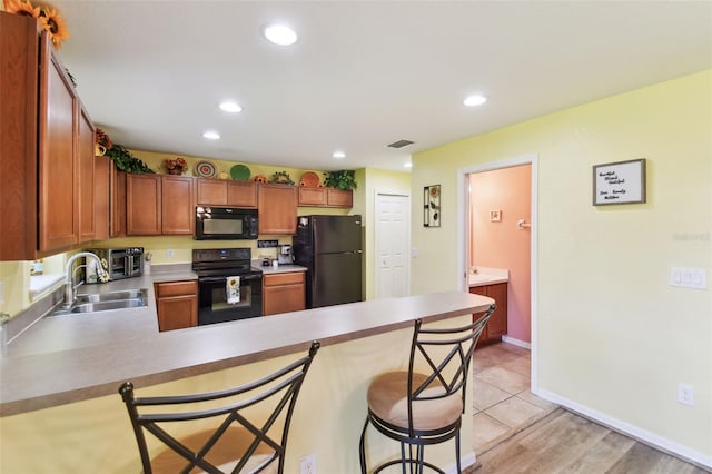 kitchen with visible vents, black appliances, a sink, recessed lighting, and a peninsula