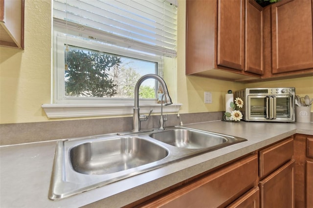 kitchen with a sink, brown cabinets, and a toaster