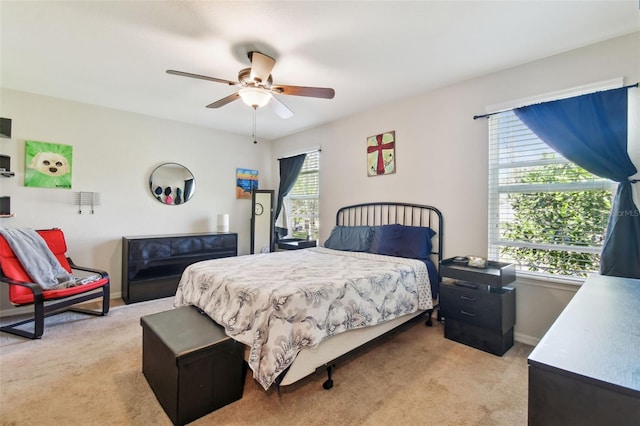 bedroom with multiple windows, light colored carpet, and ceiling fan