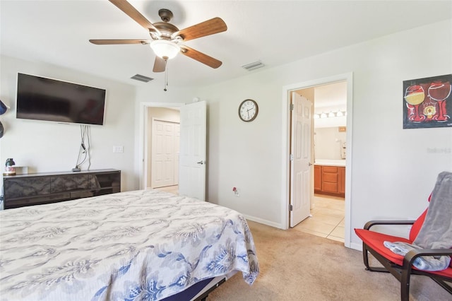 bedroom with visible vents, light colored carpet, connected bathroom, and baseboards