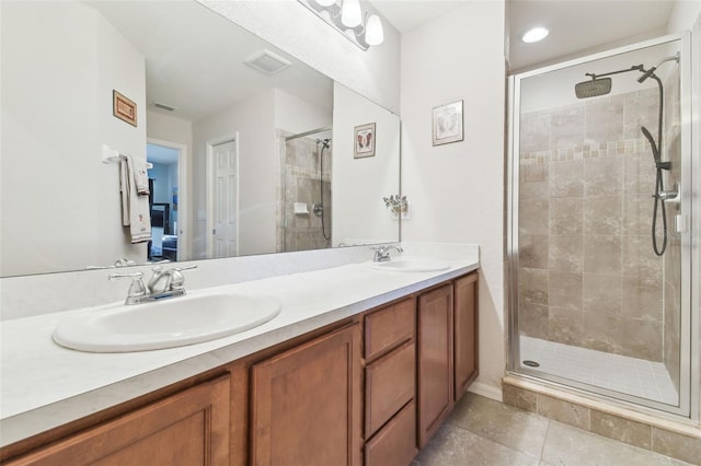 bathroom with a shower stall, double vanity, tile patterned floors, and a sink