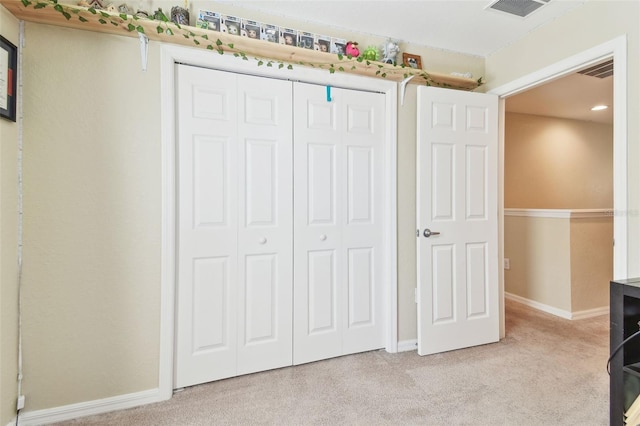 interior space with a closet, visible vents, baseboards, and carpet floors