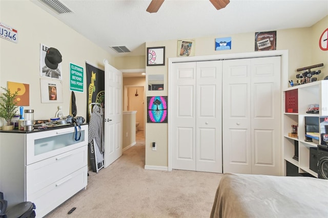 bedroom with a closet, visible vents, light colored carpet, and a ceiling fan