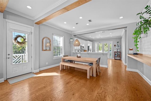 foyer with light wood-style flooring, plenty of natural light, and visible vents