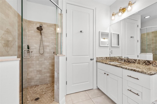 full bathroom with a stall shower, vanity, and tile patterned flooring