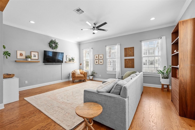 living area featuring a ceiling fan, visible vents, baseboards, light wood-style flooring, and crown molding