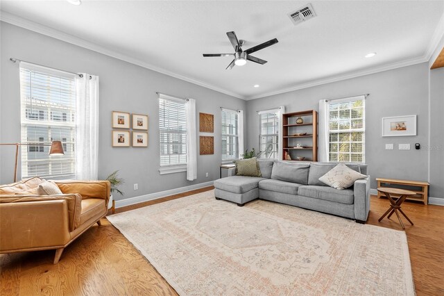 living area featuring a ceiling fan, a healthy amount of sunlight, light wood-type flooring, and baseboards