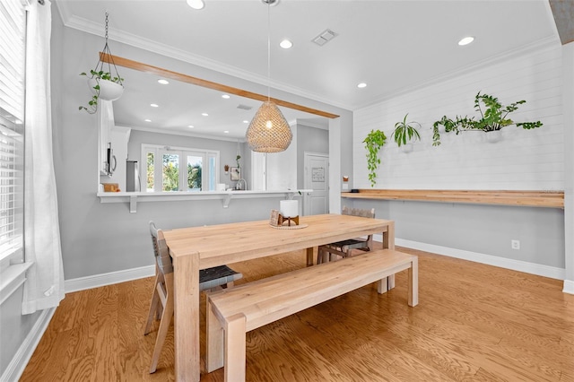 dining area with wood finished floors, visible vents, baseboards, recessed lighting, and crown molding