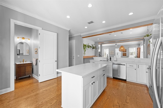 kitchen featuring a sink, light wood-type flooring, appliances with stainless steel finishes, and light countertops