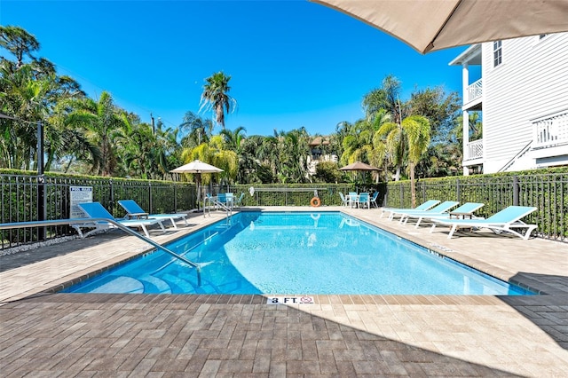 pool with a patio area and fence