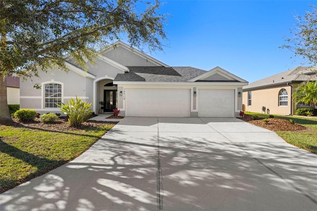 single story home featuring a shingled roof, concrete driveway, an attached garage, and stucco siding