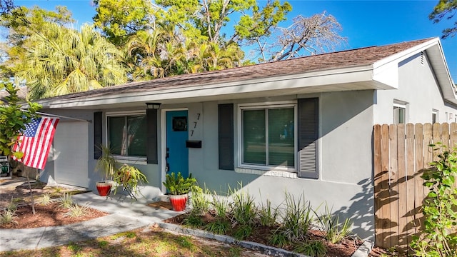 view of front of home featuring stucco siding and fence