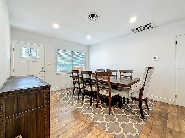 dining space with baseboards, visible vents, and light wood-type flooring