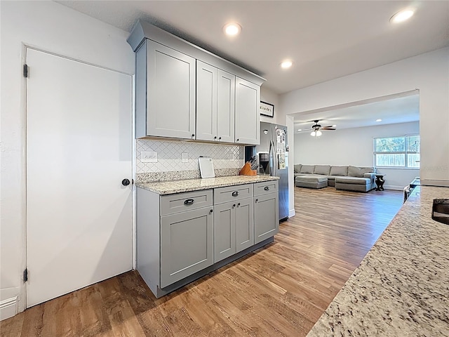 kitchen featuring a ceiling fan, light wood-style floors, gray cabinets, and stainless steel fridge with ice dispenser