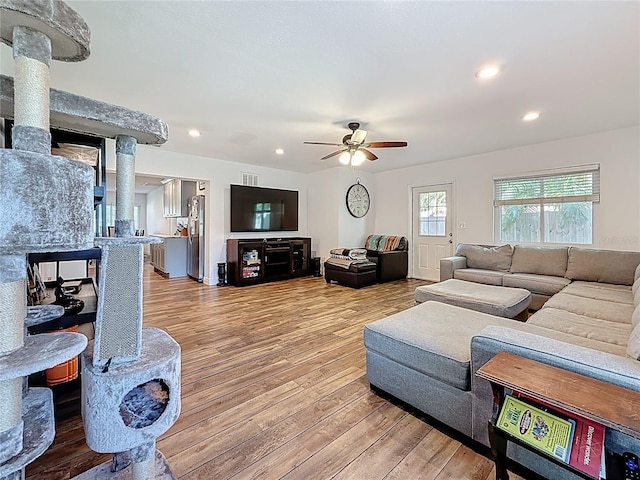 living room featuring recessed lighting, a ceiling fan, and wood finished floors