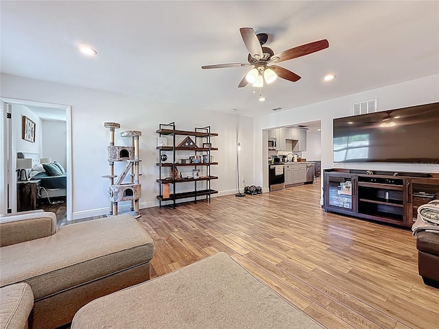 living room featuring visible vents, ceiling fan, baseboards, recessed lighting, and light wood-style floors