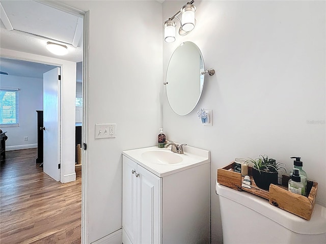 bathroom featuring baseboards, wood finished floors, and vanity