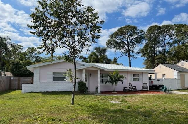 ranch-style house featuring a front lawn and fence