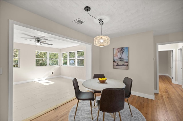 dining space featuring ceiling fan, visible vents, baseboards, and light wood-style flooring