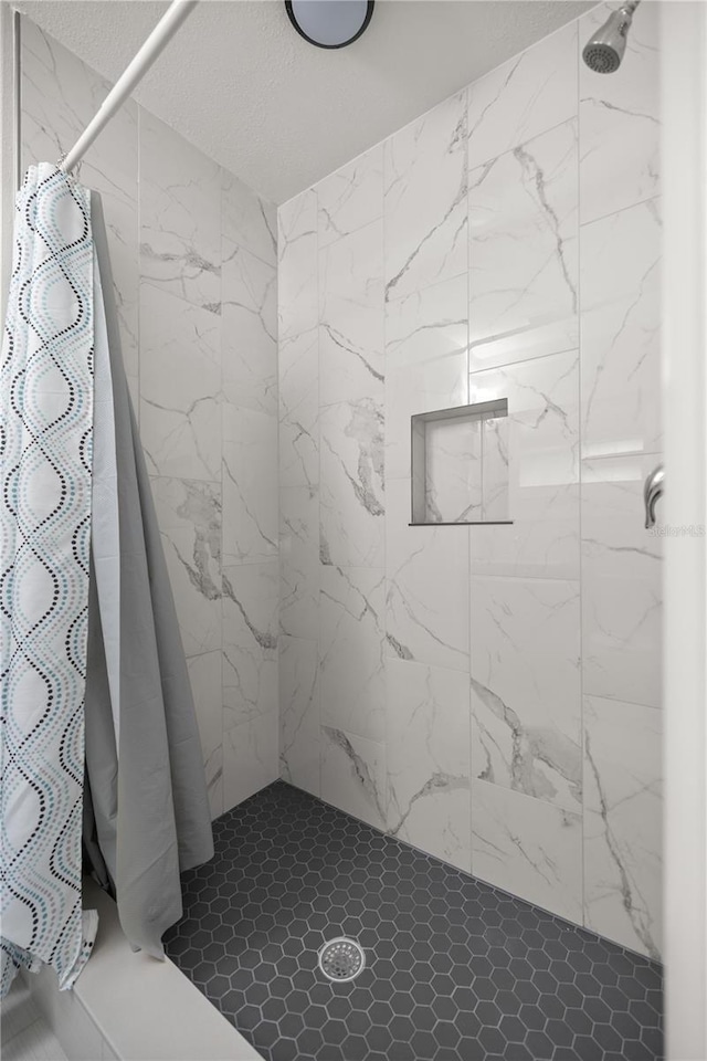 bathroom featuring a shower stall and a textured ceiling