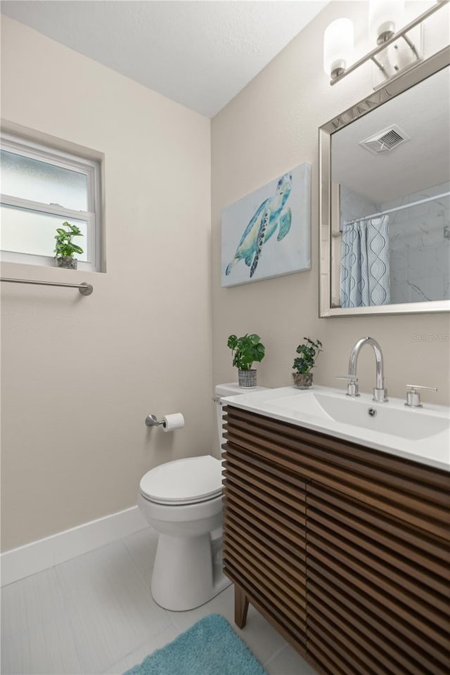 bathroom with visible vents, baseboards, toilet, tile patterned floors, and vanity