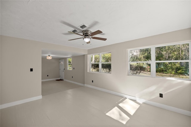 empty room with visible vents, baseboards, and a ceiling fan