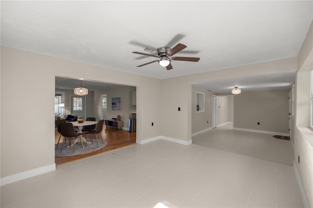 living room with baseboards and ceiling fan