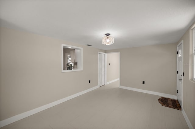 empty room with visible vents, baseboards, and light floors