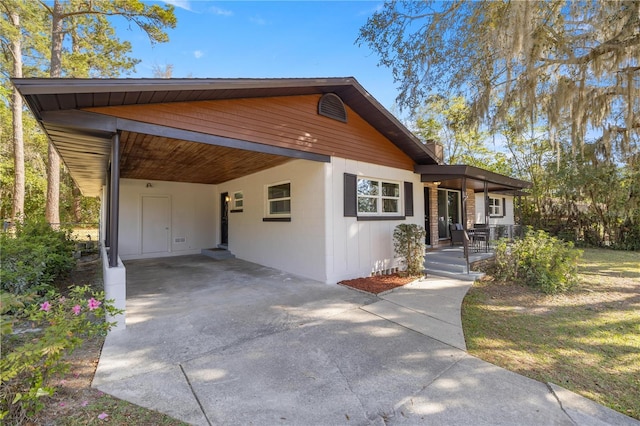 view of front facade with an attached carport and concrete driveway