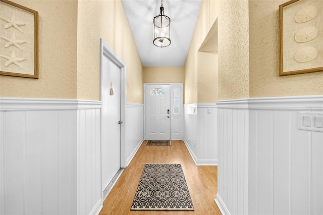 entryway featuring light wood-type flooring and wainscoting