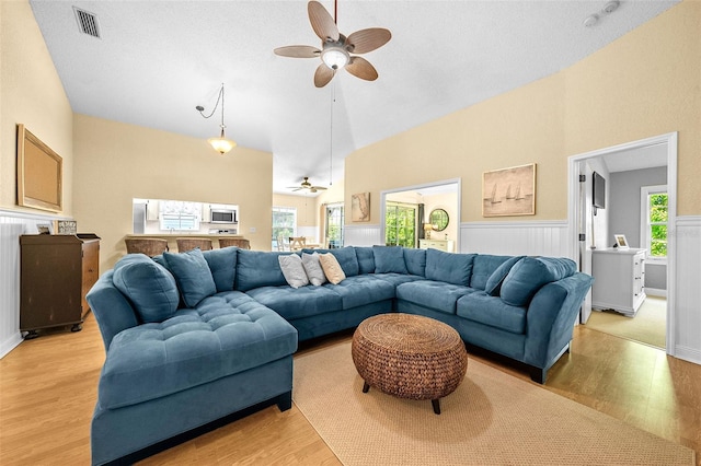 living room featuring a healthy amount of sunlight, ceiling fan, and light wood finished floors