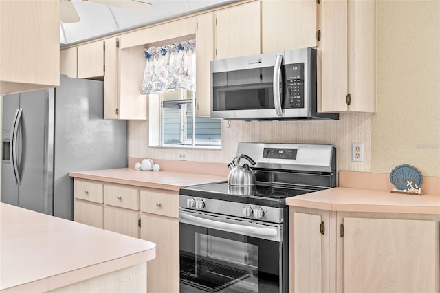 kitchen with a ceiling fan, light brown cabinetry, appliances with stainless steel finishes, light countertops, and a textured wall