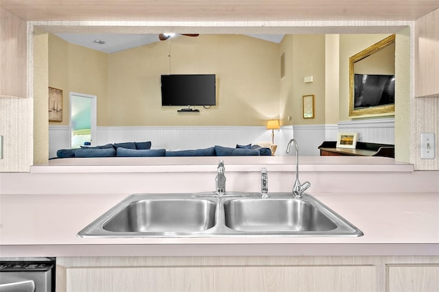 kitchen featuring a sink, light countertops, vaulted ceiling, dishwasher, and open floor plan