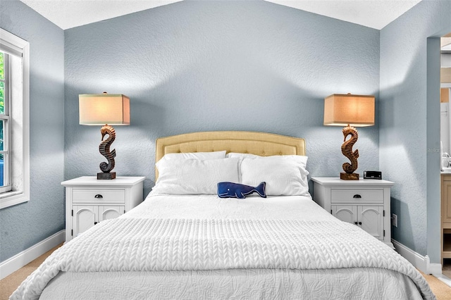 carpeted bedroom featuring baseboards and a textured wall