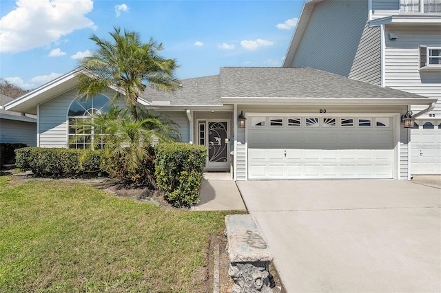 view of front of property featuring a front lawn, an attached garage, driveway, and roof with shingles