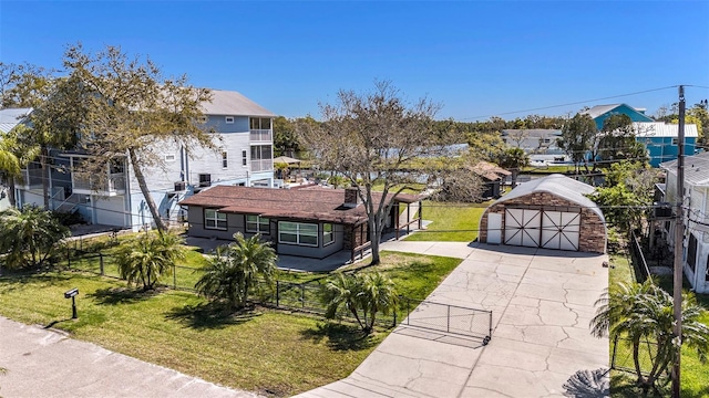 view of front of house with a gate, fence, a front lawn, an outdoor structure, and a detached garage